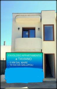 a building with a blue sign in front of it at Appartamento Pompea in Taviano