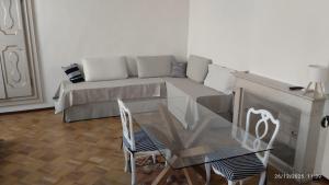 a living room with a couch and a glass table at FuoriPorta Affitti Brevi - L'Appartamento della Musica in Parma +2 photos