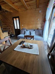 a living room with a wooden table and a couch at Vikendica Neven 2 in Zaovine