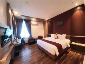 MeulabohParkside Meuligoe Hotel的酒店房间，配有一张大床和一台电视