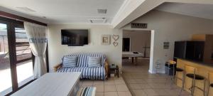 un soggiorno con un divano e una televisione di The River House - Sundays River - Addo Park South 5 min a Colchester