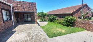 a brick house with a walkway next to a yard at The River House - Sundays River - Addo Park South 5 min in Colchester