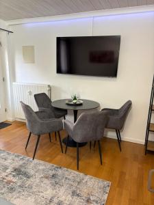 a black table with chairs and a television on a wall at Danube Rooms Abteistrasse - Self Checkin - kostenlos Parken direkt an der Unterkunft - Ideal für Geschäftsreisende und Städtetrips in Passau