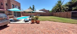 un cortile con piscina e una casa con macchina di The River House - Sundays River - Addo Park South 5 min a Colchester