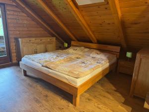 ein Schlafzimmer mit einem Bett in einer Holzhütte in der Unterkunft Ferienhaus Parschlug in Parschlug