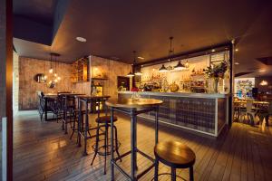 a restaurant with tables and chairs and a bar at a&o Manchester City Centre in Manchester