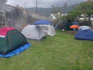 a group of tents sitting in the grass at Acampamento Aloha solemar in Praia Grande