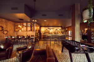 a room with a bar with leather chairs and a table at a&o Manchester City Centre in Manchester