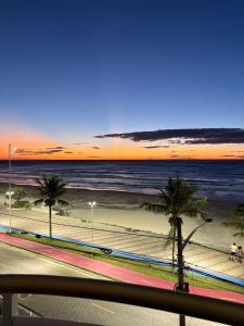a view of a beach with palm trees and the ocean at Ohana da Sandra e do William in Mongaguá