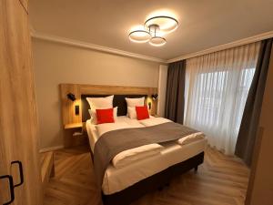 a bedroom with a large bed with two red pillows at Apartment-Hotel Hamburg Mitte in Hamburg