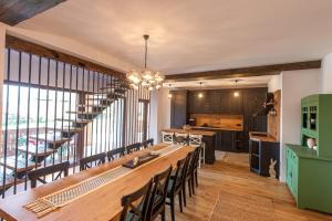 a kitchen and dining room with a long table and chairs at Pensiune Old Barn House in Vàrhegy