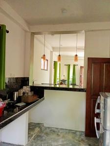 a kitchen with black counter tops and green accents at Hurley vila in Weligama