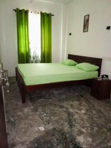 a bedroom with a large bed with green curtains at Hurley vila in Weligama