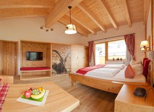 ein Schlafzimmer mit einem großen Bett und einem Tisch mit Obst auf einem Tablett in der Unterkunft Hotel Kasimir in Riezlern