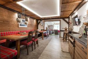 ein Esszimmer mit Holzwänden, Tischen und Stühlen in der Unterkunft Hotel Kasimir in Riezlern