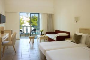 a hotel room with two beds and a living room at Kiotari Miraluna Beach Resort in Kiotari