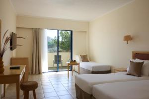 a hotel room with two beds and a window at Kiotari Miraluna Beach Resort in Kiotari +152 photos