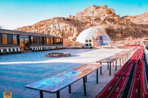 a group of benches in front of a tent at Wadi Rum in Al Jafr