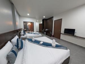 a hotel room with two beds and a flat screen tv at Tulip Elegant Riverside Hotel in Vang Vieng
