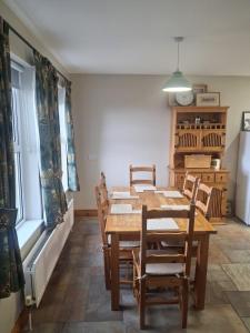 a dining room with a wooden table and chairs at Redbrae cottage in Carnlough +20 photos