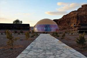 a dome building with a walkway in the desert at Wadi Rum in Al Jafr