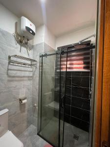 a shower with a glass door in a bathroom at Exotic Two bedroom apartment in Abuja +28 photos