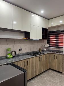 a kitchen with white cabinets and stainless steel appliances at Exotic Two bedroom apartment in Abuja