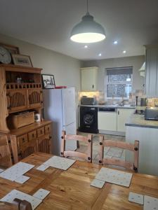 a kitchen with a table and two chairs and a refrigerator at Redbrae cottage in Carnlough