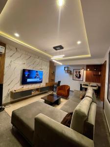 a living room with a couch and a flat screen tv at Exotic Two bedroom apartment in Abuja