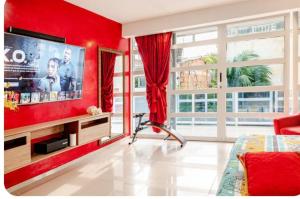 a bedroom with a red wall with a large tv at Casa con Piscina Privada Playas del Mar in Cartagena de Indias