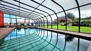 CedrosPátio Ecolodge的一座带玻璃天花板的建筑中的游泳池