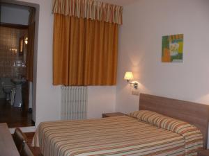 a hotel room with a bed and a window at Hostal Muntanya in Artesa de Segre