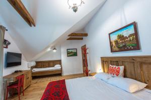 a bedroom with a bed and a desk and a television at Pensiune Old Barn House in Vàrhegy