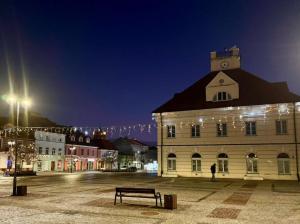a building with a clock tower on top at night at Terra Siciliana in Łęczyca