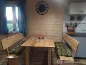 a wooden table and benches in a kitchen with a clock at Dom nad jeziorem Serwy in Serwy +18 photos