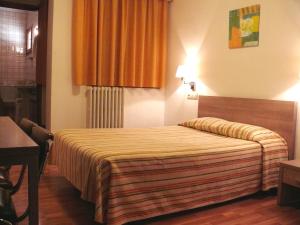 a hotel room with a bed and a lamp at Hostal Muntanya in Artesa de Segre