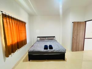 ein Schlafzimmer mit einem Bett mit blauen Schuhen darauf in der Unterkunft Winlee house in Ban Phlu Yai