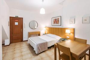 una stanza d'albergo con un letto e un tavolo di MURÇAS 74 - STUDIO APARTMENTS a Funchal