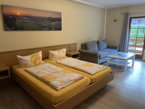 a bedroom with a bed and a couch and a chair at Pension Ostrauer Mühle in Bad Schandau