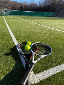 a tennis racket and balls on a tennis court at Vila Agape with a pool, football and tennis court in Lovreć