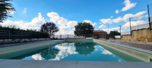 a pool of water with clouds in the sky at Bellalisa Tuscany Appartement in Sarteano