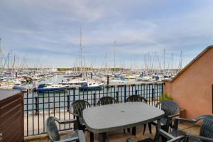 a table and chairs on a balcony with a marina at Marina View in Plymouth