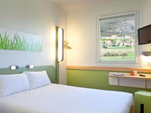 1 dormitorio con cama blanca y ventana en Ibis Budget Oviedo en Oviedo