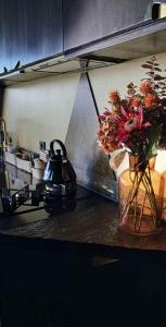 a kitchen counter with a vase of flowers and a tea kettle at Eagle Nest Eco Lodge in Sel