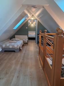 een slaapkamer op zolder met 2 bedden en een trap bij Gîte Anna du Mont-saint-Michel in Pontorson