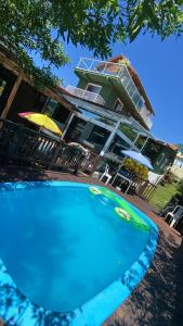 a large blue swimming pool in front of a building at Pousada Residencial Marinho in Florianópolis
