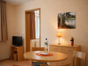 ein Wohnzimmer mit einem Tisch und einem Fernseher in der Unterkunft Bernsteinsee Hotel and Ferien by Palette Resorts in Sassenburg