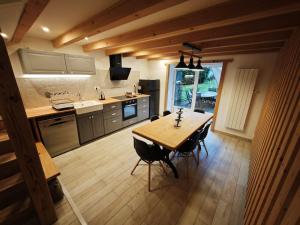 a large kitchen with a wooden table and chairs at L'orée du lac in Kruth