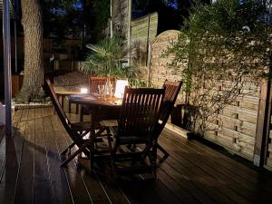 ein Holztisch und Stühle auf einer Terrasse in der Unterkunft 3 pièces avec terrasse arborée in Arcachon