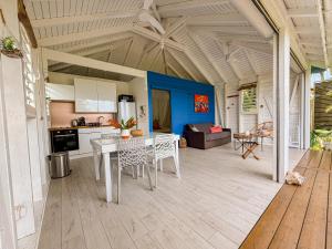 een keuken en woonkamer met een tafel en stoelen bij Au son des Grenouilles in Sainte-Rose